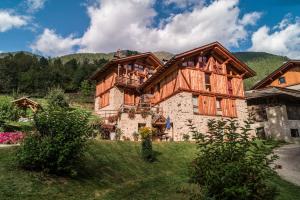 ein großes Holzhaus mit Balkon oben in der Unterkunft Maso Fior di Bosco - Val di Rabbi - Esercizio Rurale in Rabbi