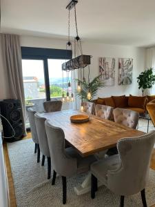 a dining room with a wooden table and chairs at Sky hill residence Mostar in Mostar
