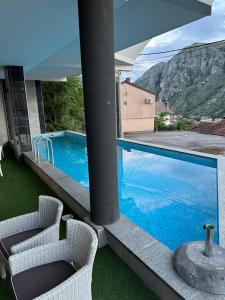 a swimming pool on a balcony with two chairs at Sky hill residence Mostar in Mostar