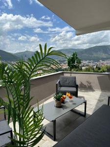 a patio with a chair and a table on a balcony at Sky hill residence Mostar in Mostar