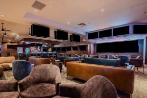 a waiting room with chairs and tables and televisions at OYO Hotel and Casino Las Vegas in Las Vegas