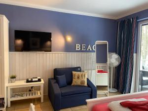 un soggiorno blu con una sedia blu e una televisione di Villa Park & Plaża a Świnoujście