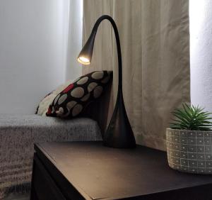 a lamp sitting on a table next to a couch at 866 Apart in San Fernando del Valle de Catamarca +3 photos
