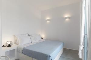 a white bedroom with a bed with white walls at Alexander Suites in Drios