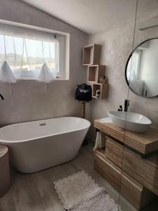 ein Badezimmer mit einer großen weißen Badewanne und einem Waschbecken in der Unterkunft Villa Rosi in Costa Paradiso