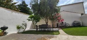 un patio con 2 sedie e un albero in un cortile di Villa Papillons Narbonne Centre a Narbonne