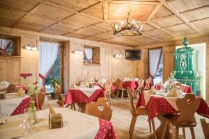 ein Esszimmer mit Tischen und Stühlen mit rotem Tischtuch in der Unterkunft Maso Fior di Bosco - Val di Rabbi - Esercizio Rurale in Rabbi