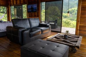 a living room with a leather couch and a table at El Indio EcoLodge in El Amparo