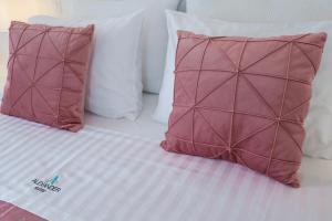 two pillows sitting on a bed with white pillows at Alexander Suites in Drios