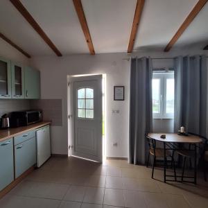 kuchnia z drzwiami i stołem w obiekcie Studio apartman Vera w Ražancu