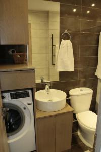 a bathroom with a sink and a washing machine at Ionian Balcony in Athani +21 photos
