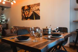 a wooden table with plates and wine glasses on it at - All-Around Skopje Apartments - Premium Hospitality - in Skopje +34 photos