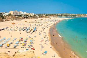 a beach with a lot of people and the ocean at T1 na 1 linha da Praia da Rocha in Portimão