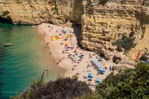 a group of people on a beach with umbrellas at T1 na 1 linha da Praia da Rocha in Portimão