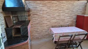 a kitchen with a table and a brick wall at Casita Oliveira in Serra Negra