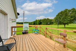 McEwenWarm and Inviting Family Home - 2 Mi to Golf Course!的带椅子的木甲板和一片田野