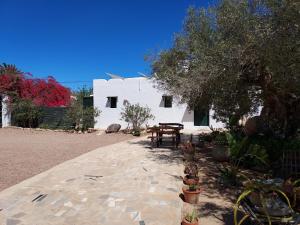 a white house with a table and some plants at Doukana in Djerba +10 photos