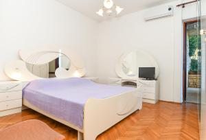 a bedroom with a bed and two mirrors at App Jadranka Matak in Rabac