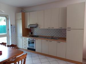 a kitchen with white cabinets and a wooden table at Casa Vacanze Relax in Agropoli