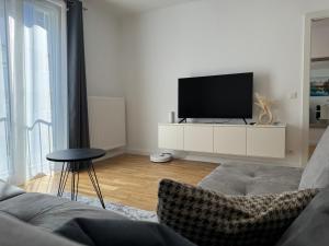 una sala de estar con TV en un armario blanco en MasimAparts Stillvolle und Familien freundliche Wohnung - Spacious, en Viena
