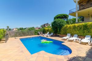 a swimming pool with chairs and a pool toy in the water at Club Villamar - Capriola 12 in Maçanet de la Selva