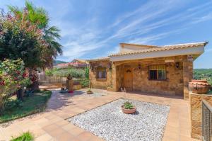 a stone house with a courtyard and a fence at Club Villamar - Capriola 12 in Maçanet de la Selva