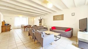 a living room with couches and a tv and a table at La Maison de la Venise Verte - 4 chambres, jardin in Le Mazeau
