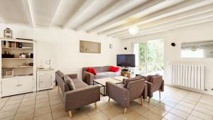 a living room with chairs and a table and a tv at La Maison de la Venise Verte - 4 chambres, jardin in Le Mazeau