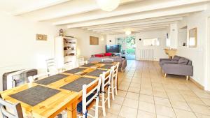 a dining room and living room with a table and chairs at La Maison de la Venise Verte - 4 chambres, jardin in Le Mazeau