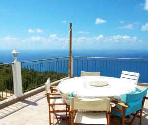 a table and chairs on a balcony with the ocean at Porto Katsiki Blu in Athani