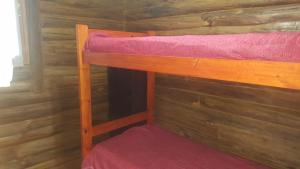 a couple of bunk beds in a log cabin at Cabaña de Don Alfonso con parque y parrilla in Gualeguaychú