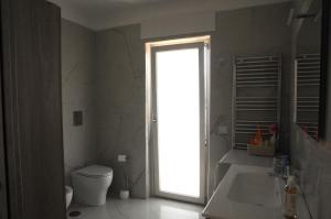 a bathroom with a toilet and a sink and a window at Casa Vacanze Villa Fiorenza in Santa Maria La Carità +15 photos