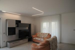 a living room with a chair and a television at Casa Vacanze Villa Fiorenza in Santa Maria La Carità