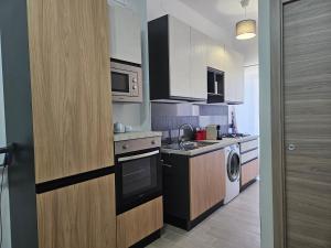 a small kitchen with a sink and a dishwasher at Casa Postierla SEA VIEW in Cefalù