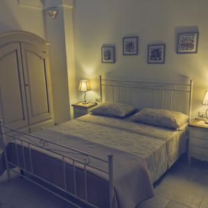 Un dormitorio con una cama con dos mesitas de noche y dos lámparas. en La casetta di Iaia - Tricase, en Tricase
