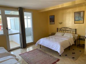 a bedroom with a bed and a large window at H&ocirc;tel Petite Su&egrave;de in Agadir