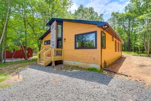 a tiny house in the woods with a porch at Pool and Beach Access Charming Poconos Cabin! in Albrightsville