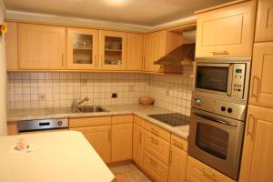 una cucina con mobili in legno e piano cottura con forno di Freines a La Valle