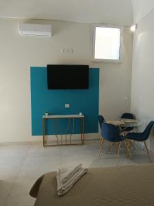 a living room with a tv and a table and chairs at Historic House in Ercolano