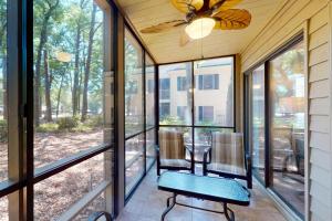 a screened porch with two chairs and a table at Pawleys Island #2 in Pawleys Island