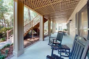 a porch with chairs and stairs on a house at Pawleys Island #2 in Pawleys Island