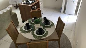 een eettafel met stoelen en een tafel met borden bij Desativado in Petrolina +2 foto's