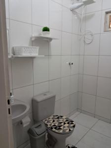 een witte badkamer met een toilet en een wastafel bij Desativado in Petrolina