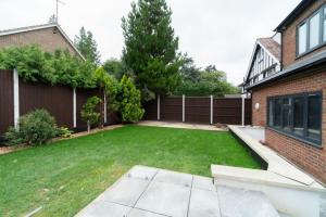 a backyard with a lawn and a fence at Purley 2 Bed Flat in Purley