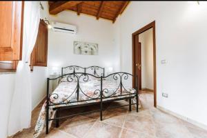 a bedroom with a wrought iron bed in a room at Villetta Gio in Olìa Speciosa