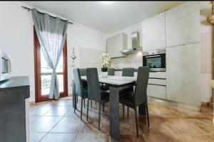a kitchen with a dining room table and chairs at Villetta Gio in Olìa Speciosa