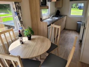 una cucina con un tavolo con una bottiglia di vino di Chalet bij Lente van Drenthe nabij meer a Gasselte