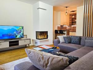 a living room with a couch and a tv at Apartman Kadic Bjelasnica - Free Private Garage Parking in Bjelašnica