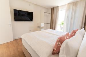 een witte slaapkamer met een bed en een televisie bij Villa Bellevue in Mostar +32 foto's