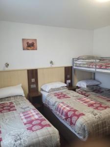 a room with two beds and two bunk beds at The Gatwick White House Hotel in Horley